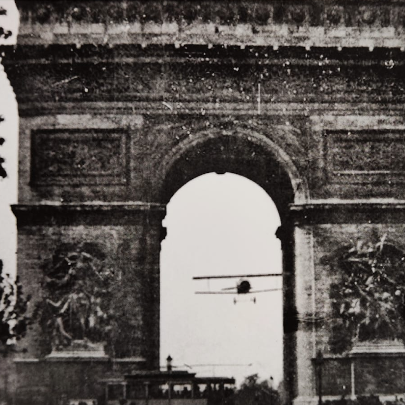 Photo noir et blanc d'un avion passant sous l'Arc de Triomphe en août 1919