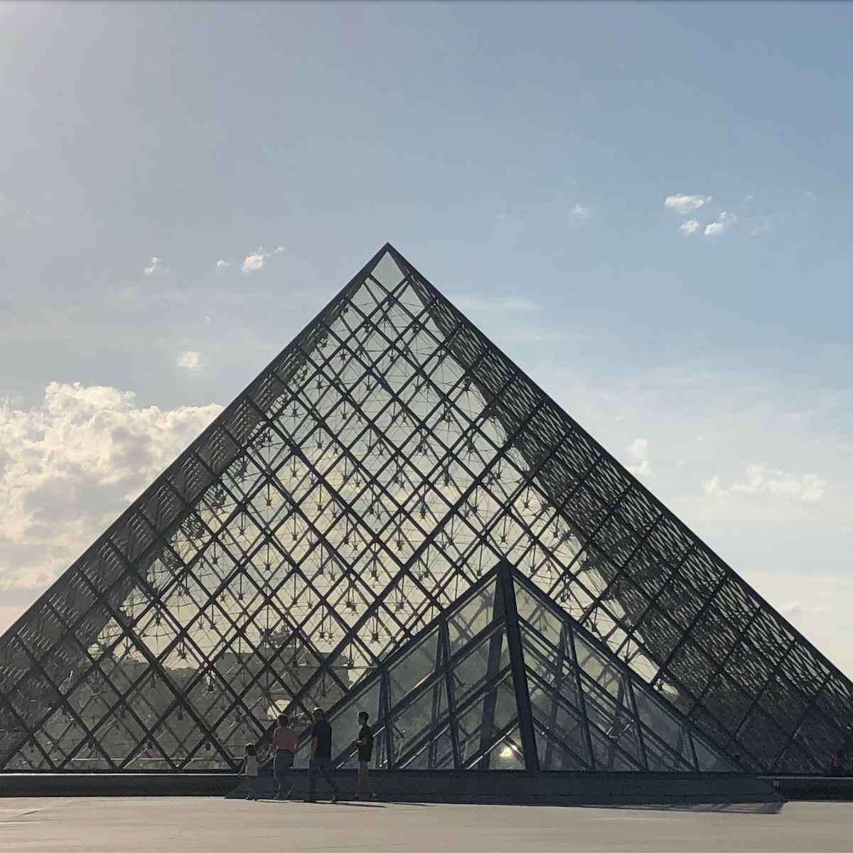 Vue de la pyramide du Louvre, transparente, ciel bleu.