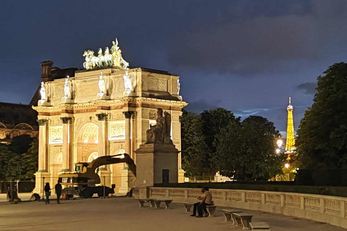 l'arc de triomphe du carrousel et la tour Eiffel, tous deux illuminés de nuit.