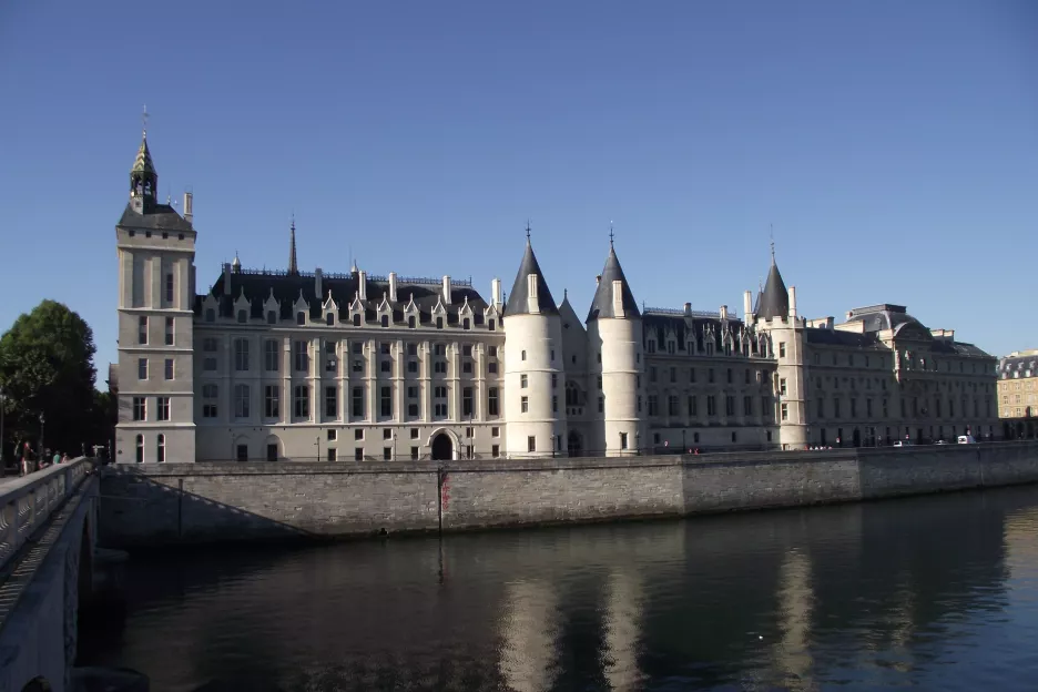 vue sur la façade coté Seine du palais de la cité autrement nommé Conciergerie, avec des reflets des tours dans le fleuve par grand beau temps.