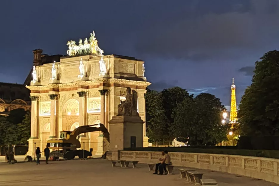 l'arc de triomphe du carrousel et la tour Eiffel, tous deux illuminés de nuit.