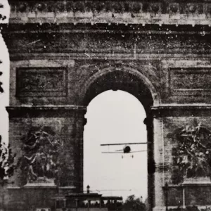 Photo noir et blanc d'un avion passant sous l'Arc de Triomphe en août 1919