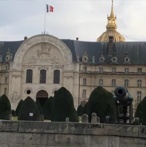 Vue du porche de l'Hôtel des Invalides avec un canon et le dôme dans le fond